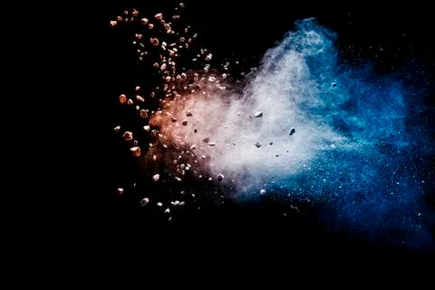 Split debris of stone exploding with blue red powder against black background Stock Photos