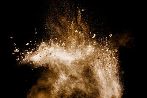 Split debris of stone exploding with brown powder against white background. Stock Photos