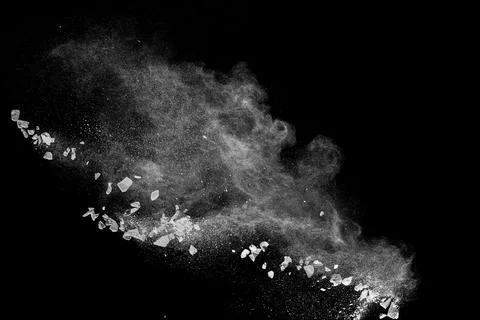 Split debris of  stone exploding with white powder against black background. Stock Photos