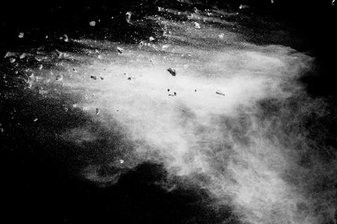 Split debris of  stone exploding with white powder against black background. Stock Photos