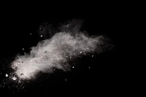 Split debris of  stone exploding with white powder against black background. Stock Photos