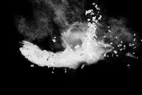 Split debris of  stone exploding with white powder against black background. Stock Photos