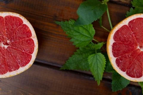 Split grapefruit on a brown wooden background, top view, text space, citrus Photos