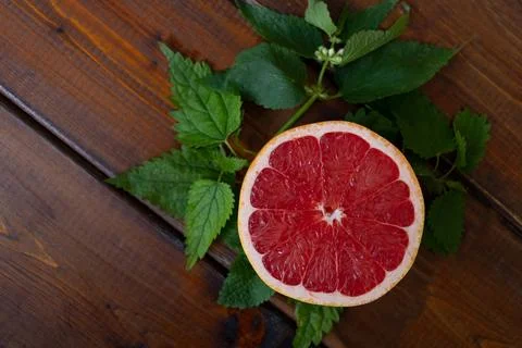 Split grapefruit on a brown wooden background, top view, text space, citrus Photos