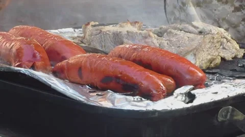 Split Hotdogs and Steak Smoking on a Charcoal Barbeque Grill Stock Footage 237475659