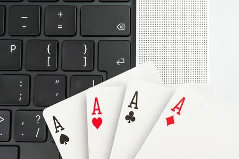 A split image featuring a laptop showing code and playing cards in a fan sh.. 库存照片