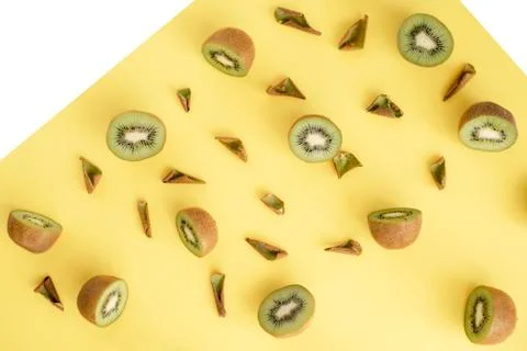 Split kiwi in half and dried peel on yellow background Stock Photos
