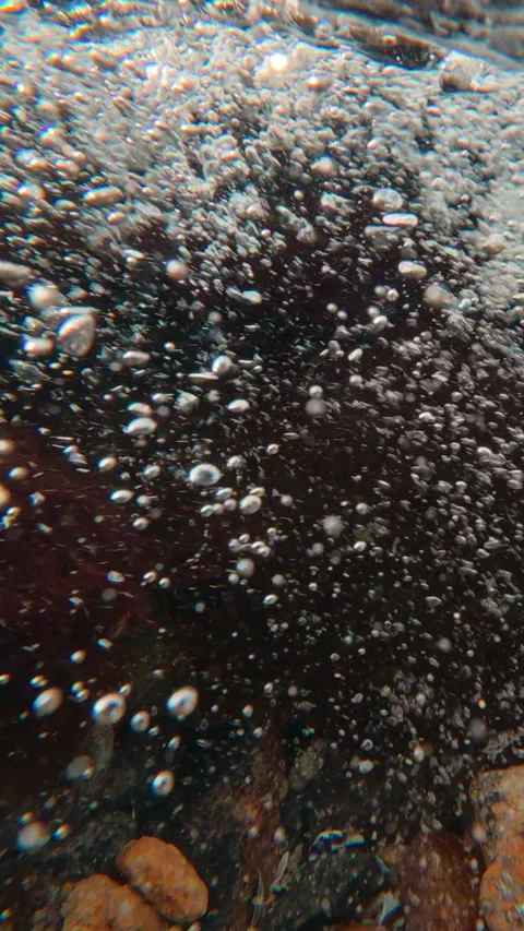 Split level, camera slowly descends underwater into stormy stream of mountain Stock Footage 336000524