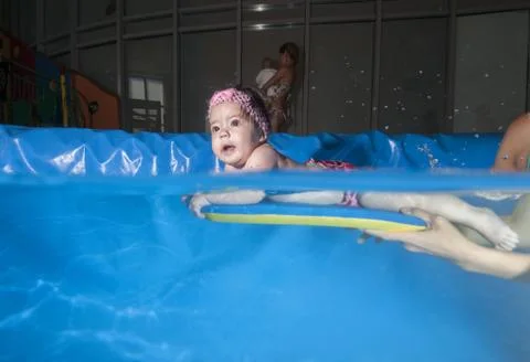 Split level, Infant swiming under water in the pool Foto stock