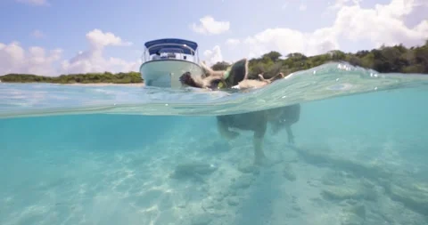 Split level shot of a boat floating in clear turquoise tropical water near Stock Footage 334251934