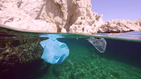 Split level underwater shot, Plastic and other garbage swims under surface of Video stock 312856885