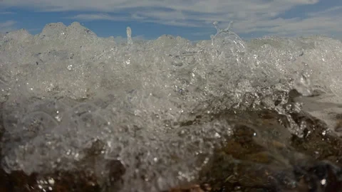 Split level, Underwater view of sea waves roll on pebbles shore during storm, Video stock 320786233