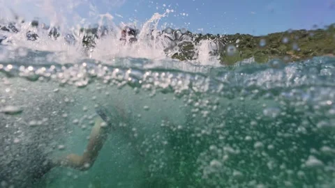 Split level view of a boy jumping into the sea water with splash 스톡 동영상 338182117