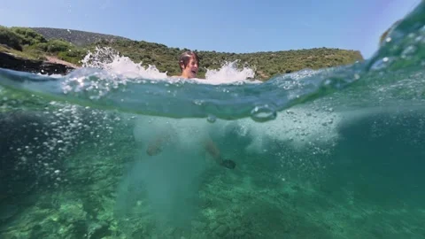 Split level view of a boy jumping into the sea water with splash 스톡 동영상 338182323