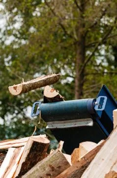 Split log flying off a conveyor belt of splitting machine Stock Photos