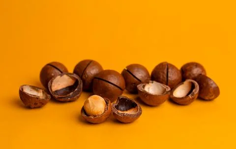 Split macadamia nut close-up on an orange background Stockfoto's