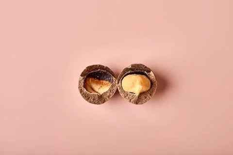 Split macadamia nut on a pink powdery background Stock Photos