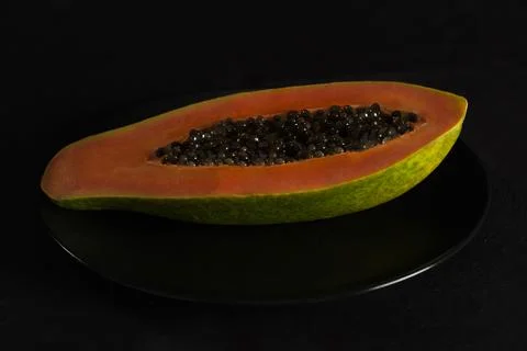 Split papaya on black background Stock Photos