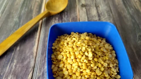 Split peas close-up in a blue bowl on a wooden table Stock Footage 230015021