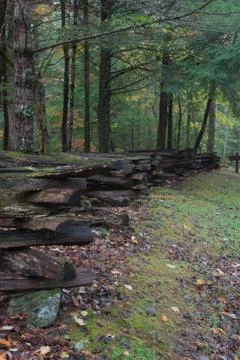 Split rail fence view from side, along an embankment with fall leaves Stock Photos