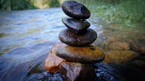 Split rock on the water, four layers of rock. Stock Photos