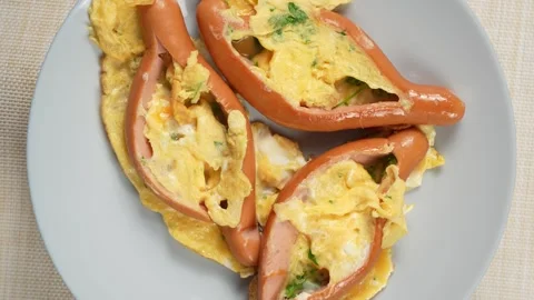 Split Sausages with Cooked Egg and Green Herbs on a Gray Plate 스톡 동영상 342615468