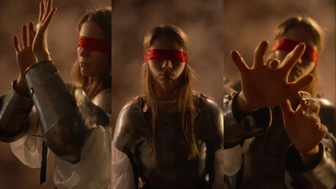 Split Screen of Blindfolded Woman in Armor Reaching Forward in Darkness Stock Footage 345506616