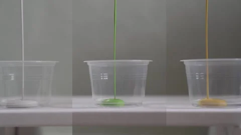 Split Screen of Paint Pouring into Plastic Cups Stock-Footage 139264921