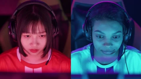 Split screen, portraits of a two woman focused gamers in headphones, the Stock Footage 252576443