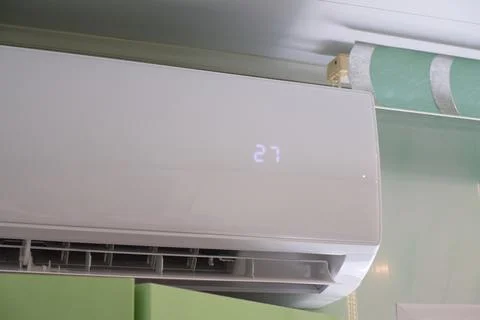 The split system shows a cooling temperature of 27 degrees Celsius. Stock Photos