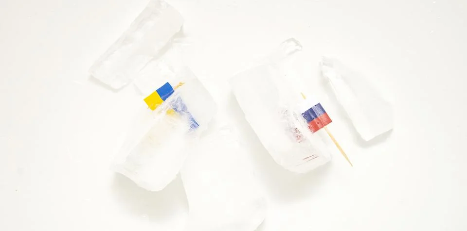 The split of two friendly countries. Two flags frozen in ice flags of Russia  Stock Photos