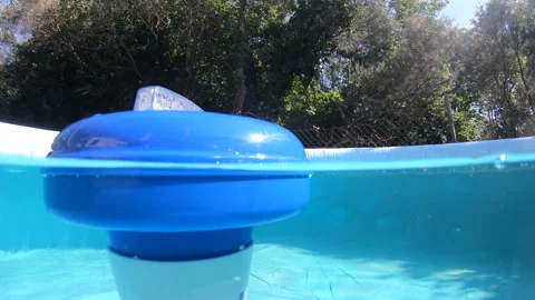 Split underwater of a chlorine dispenser floating in a pool Stock Footage 275607426