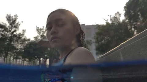 Split underwater shot of Southeast Asian girl looking at the camera Stock Footage 117906180