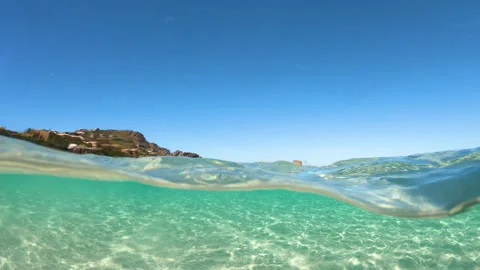 Split underwater slow motion view of La Pelosa sea with distant watchtower 스톡 동영상 334737789