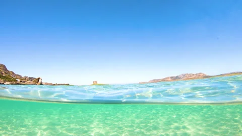 Split underwater view of La Pelosa beach on a sunny day in slow motion Stock Footage 332662278