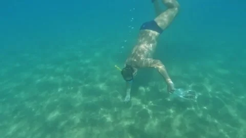 Split underwater view of man diving with bag for mussels Видео 279869118