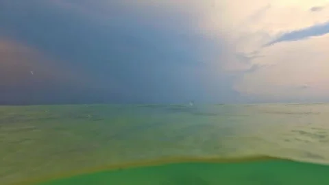 Split underwater view of rain drops pouring over sea water surface Stock Footage 278947035