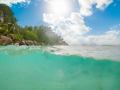 Split underwater view of a tropical beach under a shining sun Stock Photos