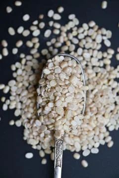 Split Urad Dal in Spoon, Angled Top View Macro Shot with Defocused Black Ba.. Stock-Fotos