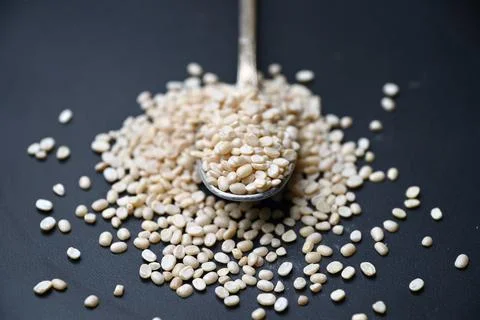 Split Urad Dal in Spoon with Black Defocused Background Angled Top View Mac.. 스톡 사진