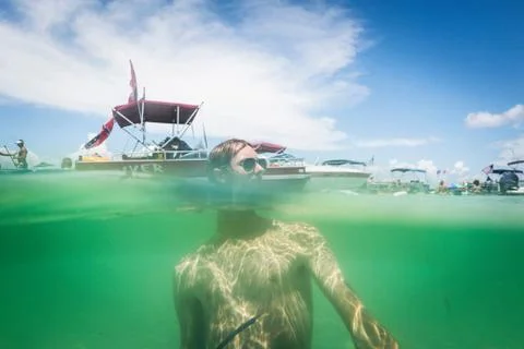 Split water level surface image of teenage boy in water, Crab Island, Emerald Foto stock