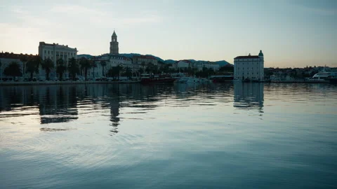 Split waterfront and historic city reflected in calm water just before sunset Vídeo Stock 347349381
