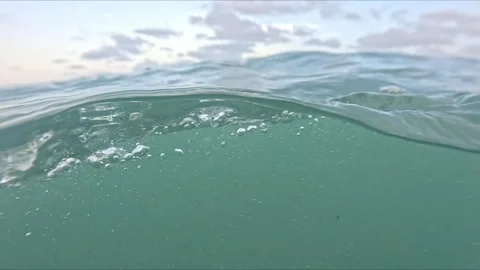 Split waterline view in the ocean showing bubbles, foam and surface waves t.. Stock Footage 318723787