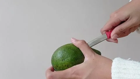 Splitting the avocado with a small red knife Stock Footage 149957082