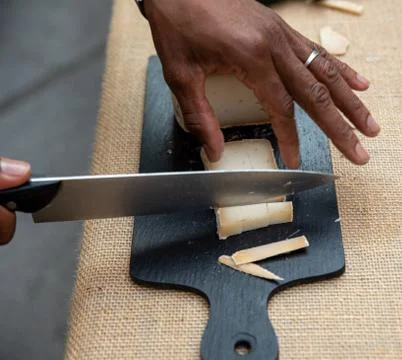 Splitting cheese on a slate. Stock Photos