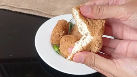 Splitting the fried brown tofu into two pieces Stock Footage 150398117