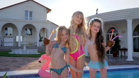 Spoiled children posing on camera near pool and villa, kids celebrities in Stock Footage 78038509