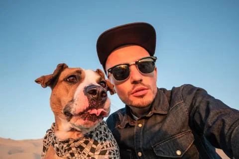 Spoiled self portrait concept: man trying to make a selfie with his funny dog Stock Photos