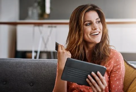 Spoiling yourself got so much simpler. an attractive young woman using a digital Stock Photos