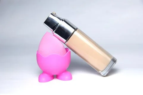 Sponge for the base. Pink sponge for makeup. Bottles of foundation Stock Photos